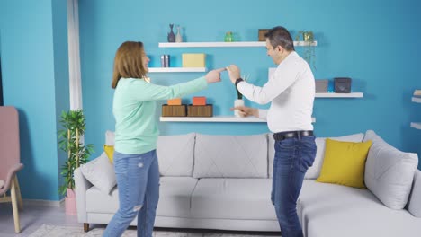 Father-and-young-adult-daughter-dancing-at-home.